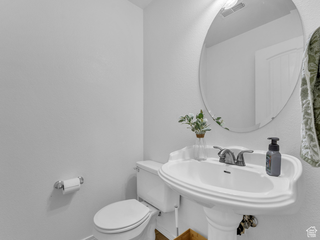 Bathroom with toilet, baseboards, and visible vents