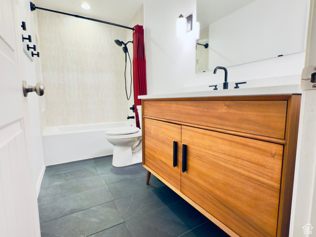 Bathroom with toilet, tile patterned floors, vanity, and washtub / shower combination