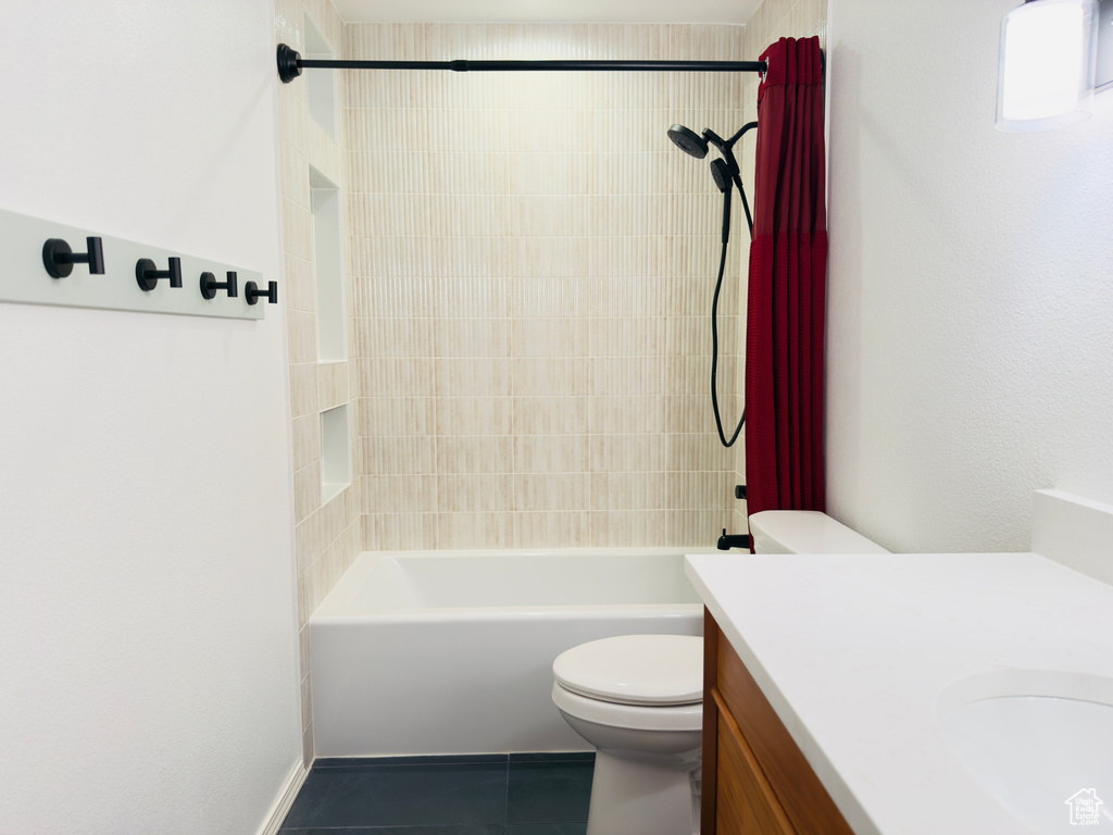 Full bathroom with toilet, vanity, tile patterned floors, and shower / washtub combination