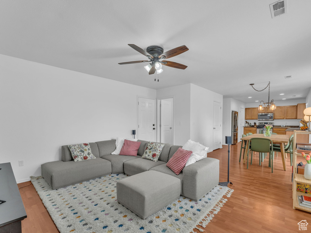Living room featuring visible vents, recessed lighting, light wood finished floors, ceiling fan, and baseboards