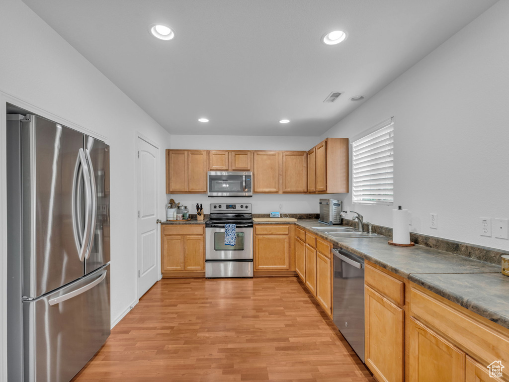 Kitchen with recessed lighting, stainless steel appliances, light wood-type flooring, and visible vents