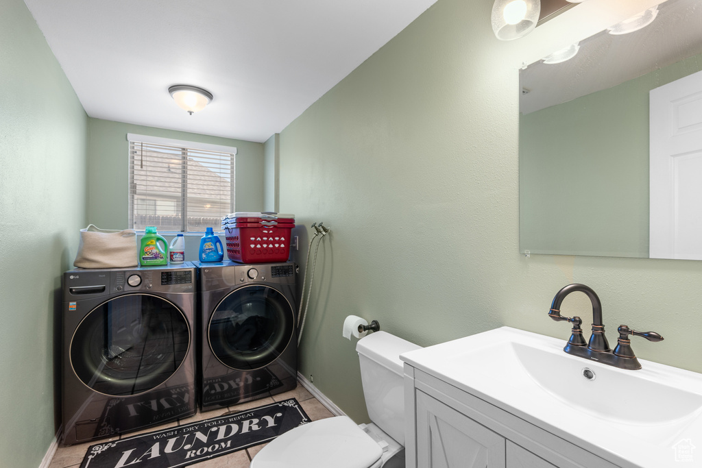 Clothes washing area featuring independent washer and dryer, baseboards, and light tile patterned flooring
