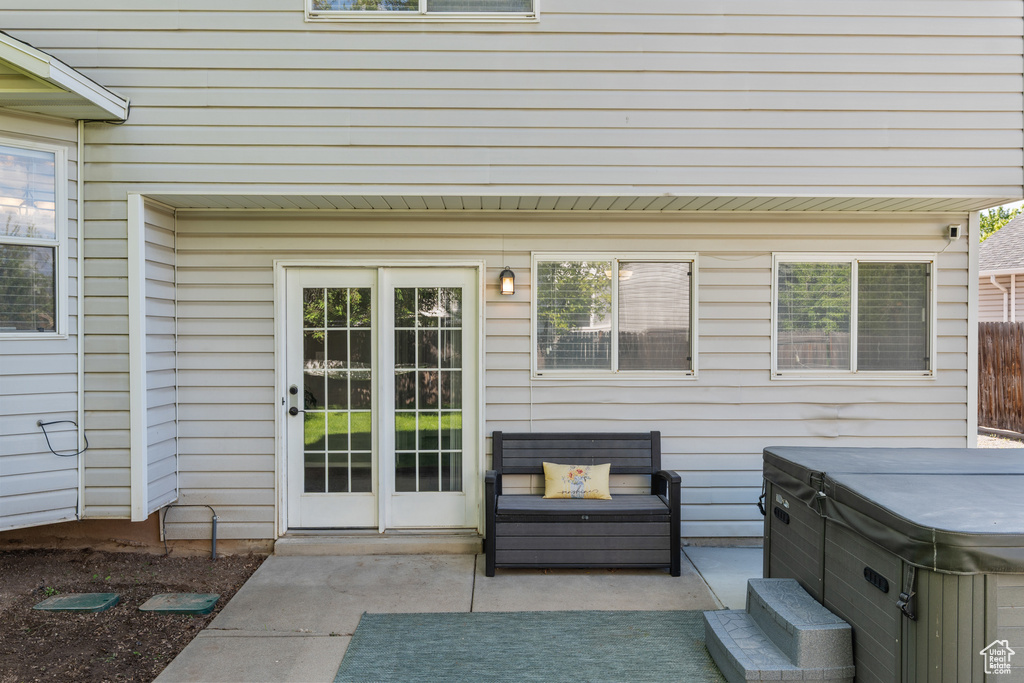 Doorway to property featuring a hot tub and a patio