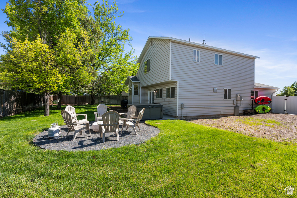 Back of property with a patio and a hot tub