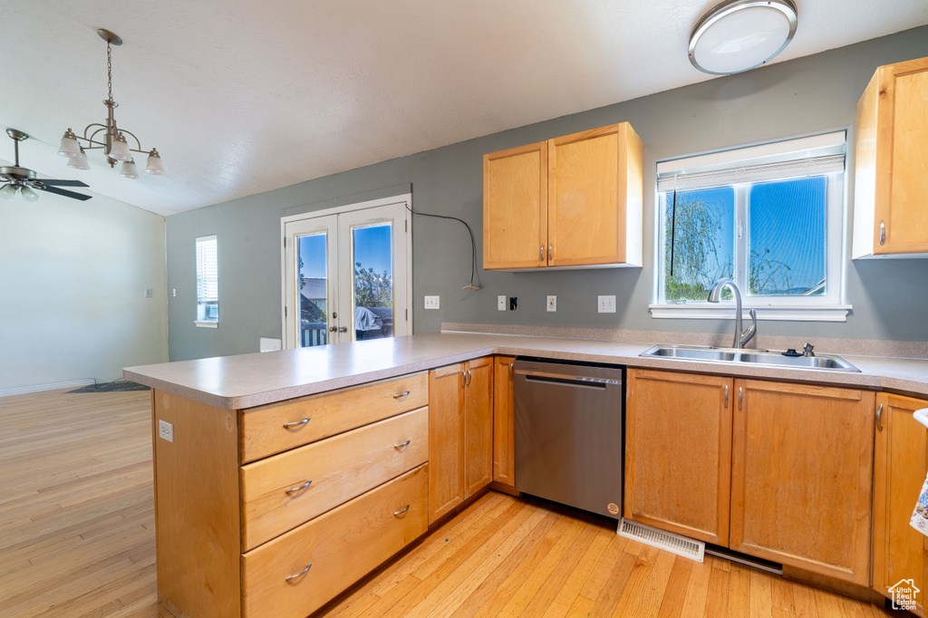 Kitchen featuring dishwasher, a sink, a peninsula, french doors, and light wood finished floors