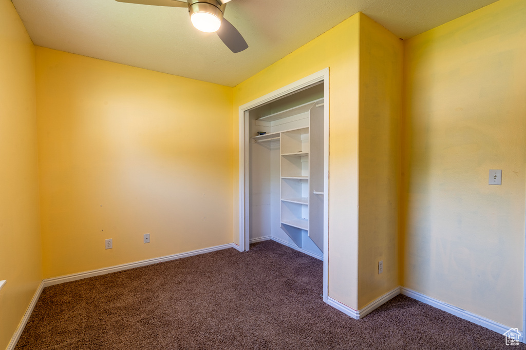 Unfurnished bedroom featuring carpet flooring, baseboards, and a ceiling fan