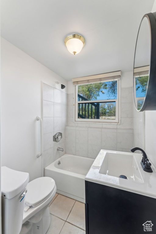Full bathroom featuring tile patterned floors, toilet, vanity, and bathing tub / shower combination
