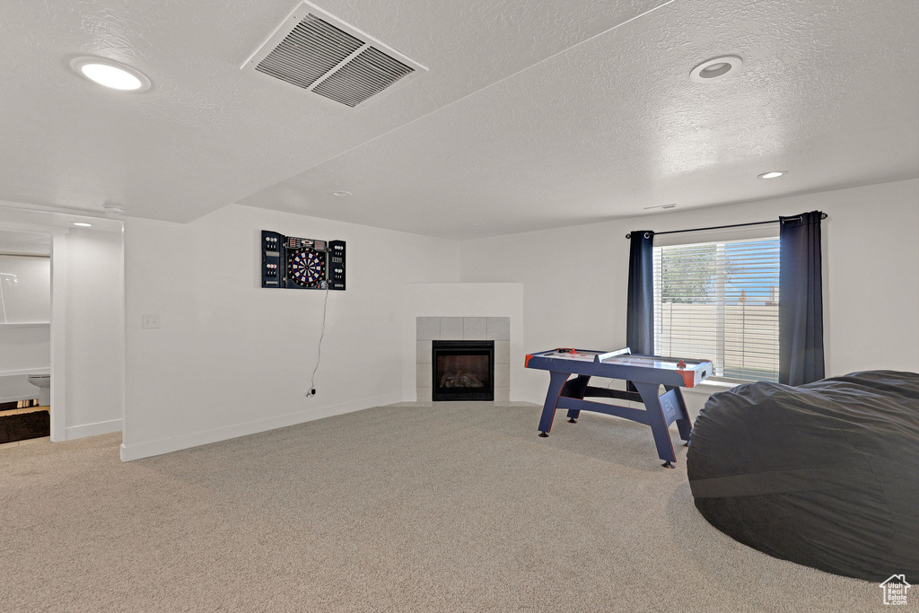 Playroom featuring carpet, a fireplace, a textured ceiling, recessed lighting, and baseboards