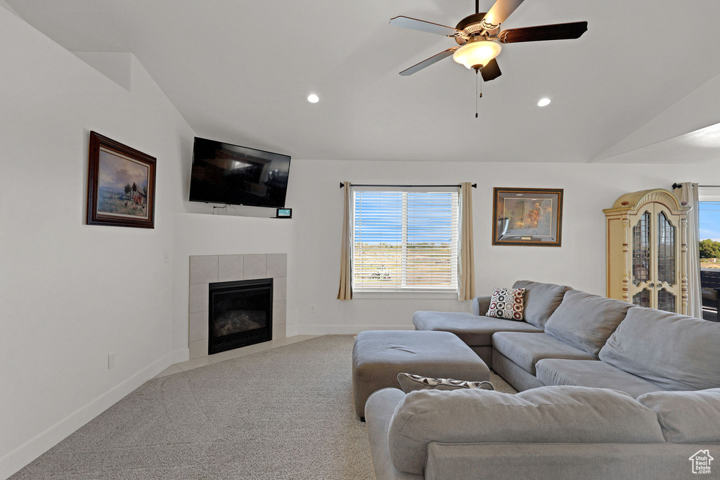 Carpeted living area featuring recessed lighting, a ceiling fan, plenty of natural light, a fireplace, and vaulted ceiling