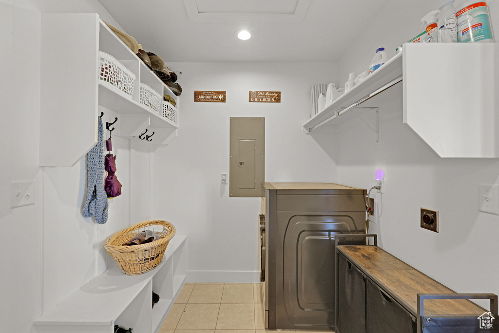 Laundry area with hookup for an electric dryer, electric panel, hookup for a washing machine, recessed lighting, and light tile patterned floors