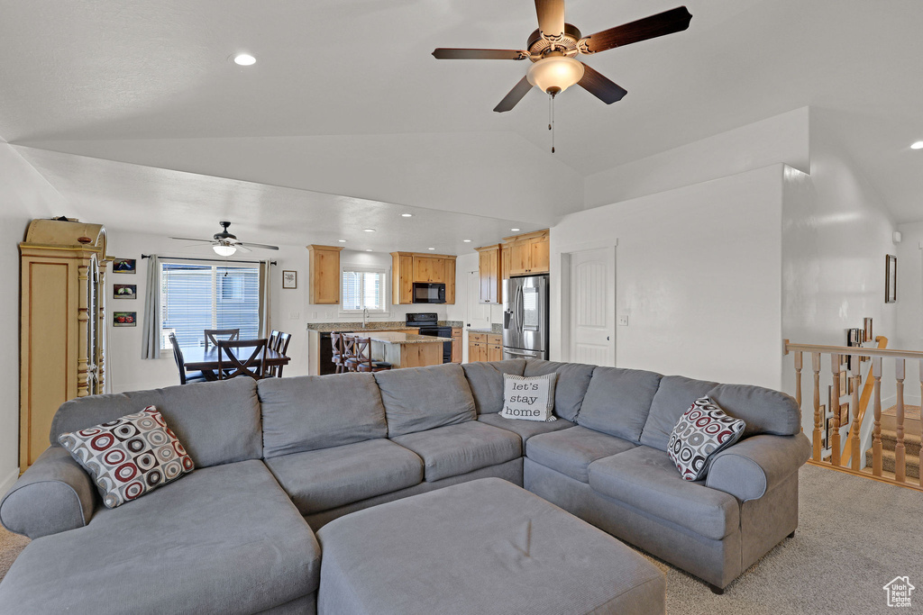 Living room featuring a ceiling fan, vaulted ceiling, light colored carpet, and recessed lighting