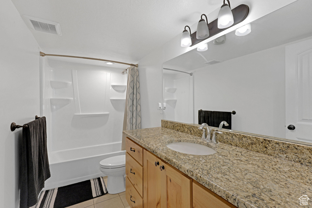 Full bathroom featuring tile patterned floors, toilet, shower / bath combo, and vanity