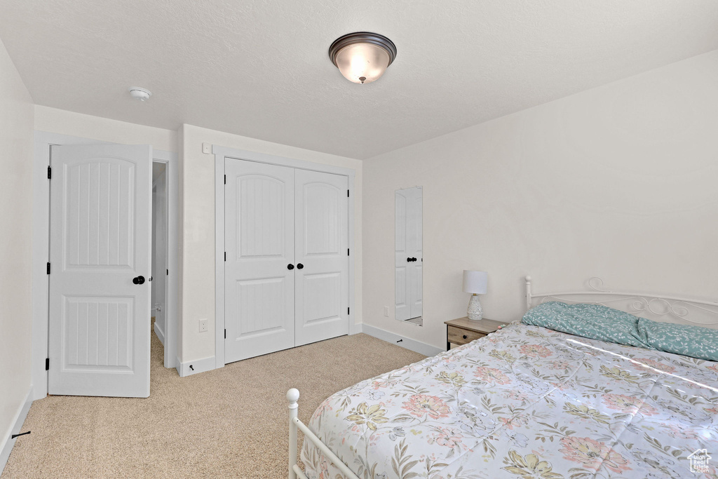 Bedroom featuring carpet flooring, a closet, and baseboards