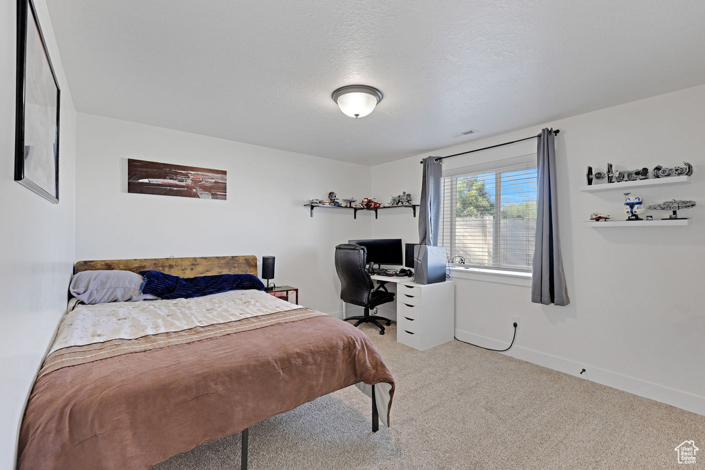 Bedroom featuring carpet floors, an office area, and baseboards