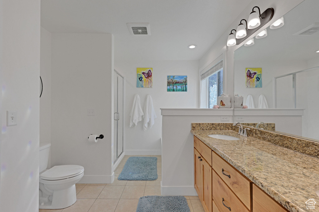 Full bathroom featuring toilet, tile patterned floors, vanity, a shower stall, and baseboards