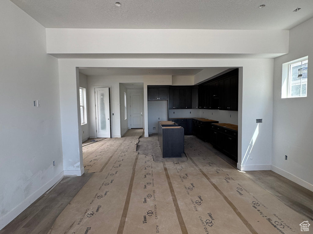 Kitchen featuring dark cabinets, baseboards, and a center island