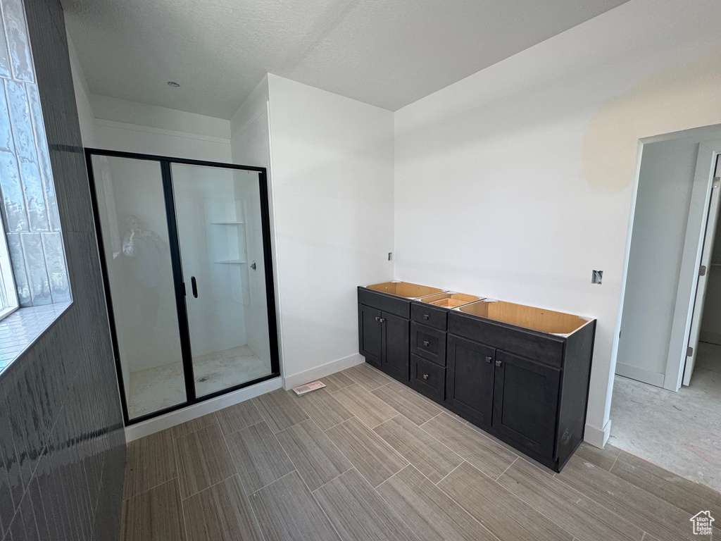 Full bathroom with a stall shower, baseboards, and wood tiled floors