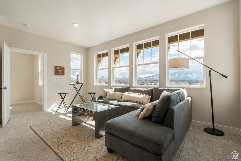 Living area with carpet floors, baseboards, and recessed lighting