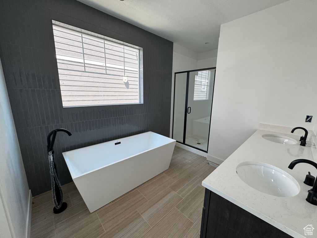 Bathroom with a shower stall, a freestanding bath, and double vanity