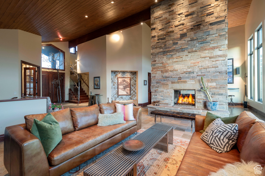 Living area featuring wood ceiling, a high ceiling, stairway, a fireplace, and recessed lighting
