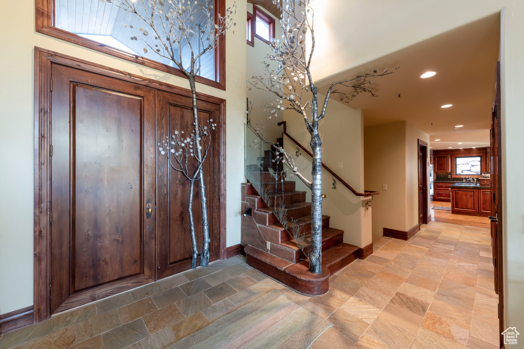 Entrance foyer with stairs, recessed lighting, and baseboards