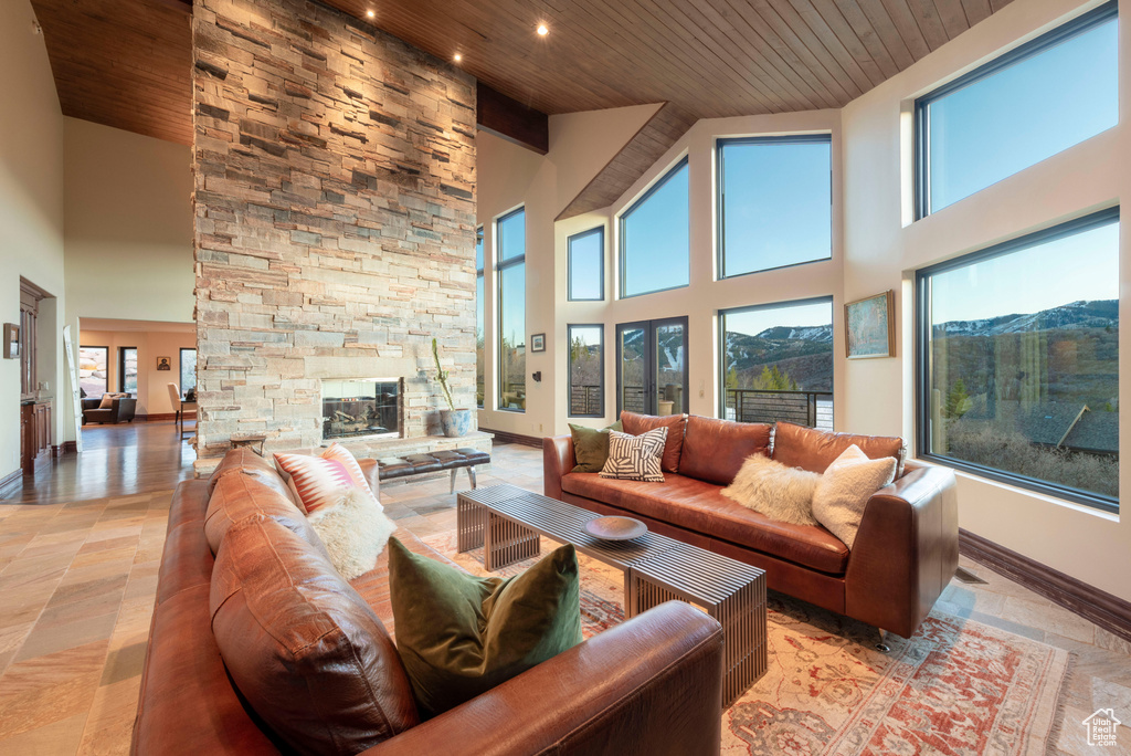 Living area featuring wood ceiling, high vaulted ceiling, a fireplace, baseboards, and recessed lighting