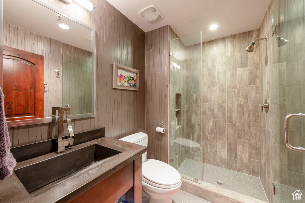 Full bath with toilet, a stall shower, and vanity