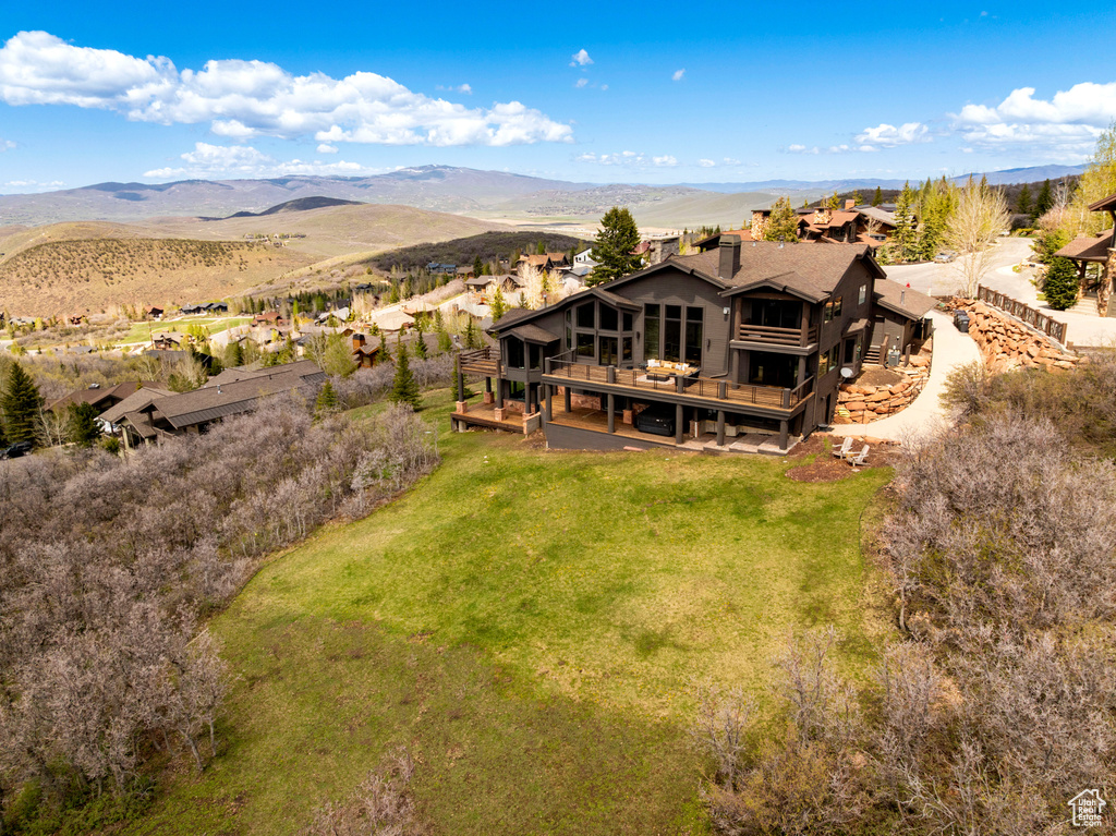 Aerial view of property and surrounding area featuring a mountain backdrop