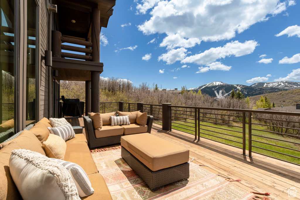 Wooden terrace with an outdoor hangout area and a mountain view