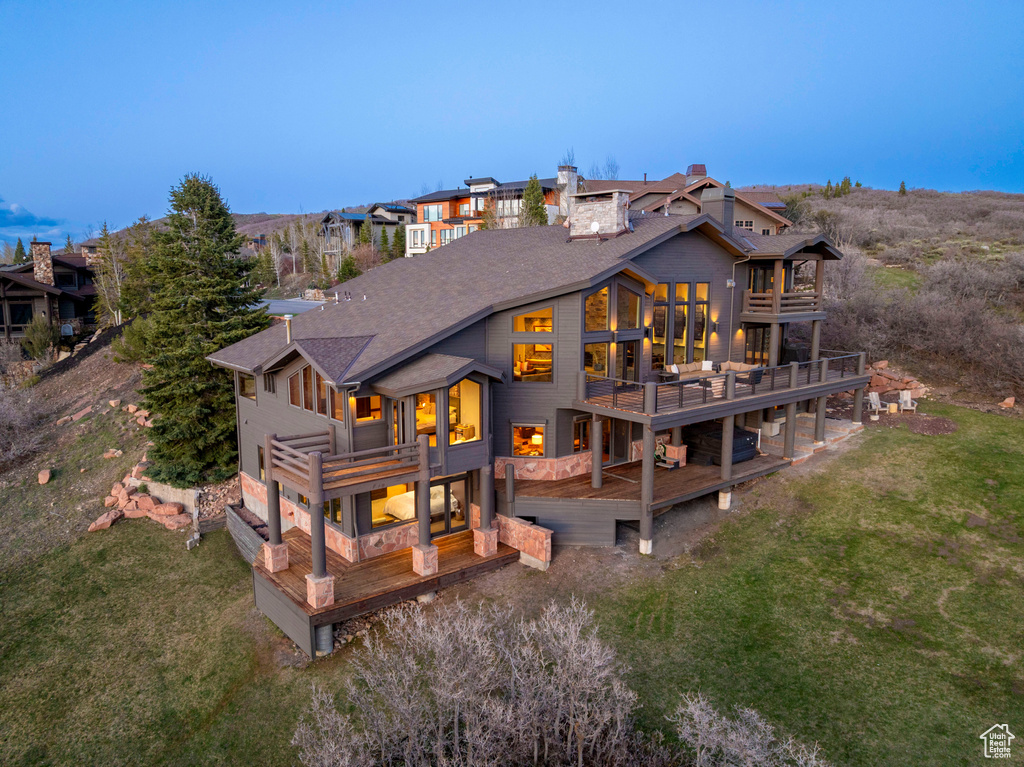 Back of property with a balcony, a wooden deck, and a yard
