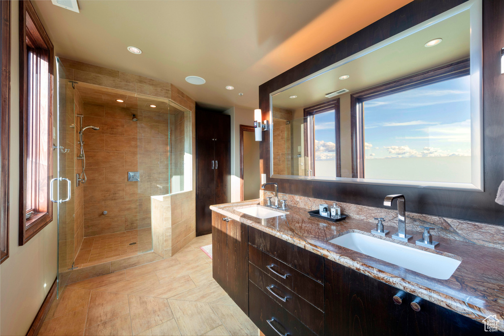 Full bath with a stall shower, healthy amount of natural light, double vanity, and recessed lighting