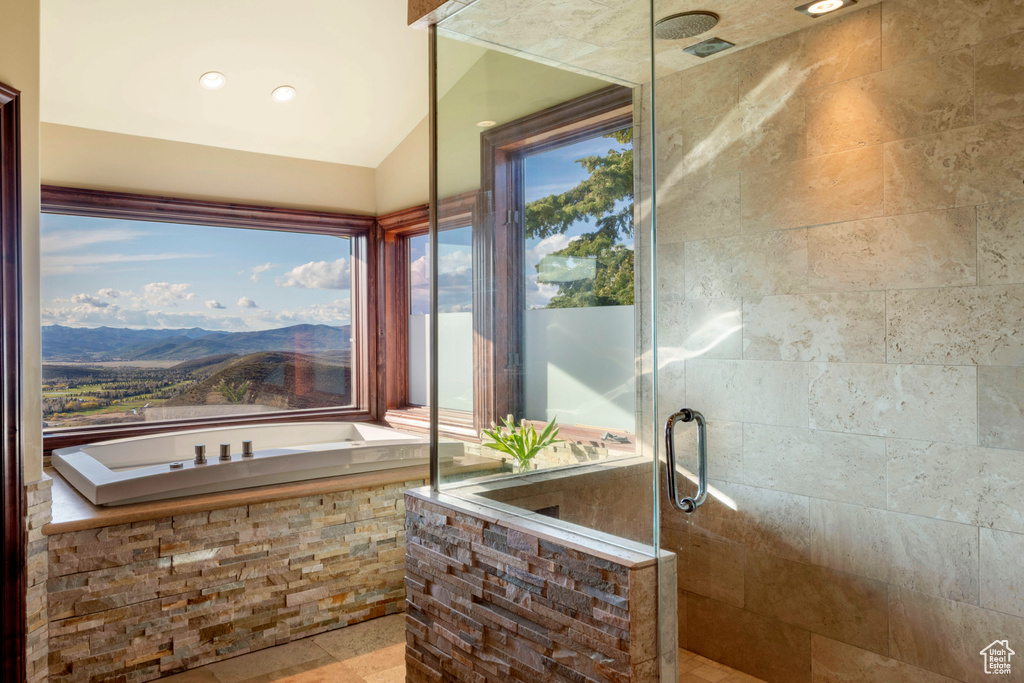 Full bath featuring tiled shower, a mountain view, and lofted ceiling
