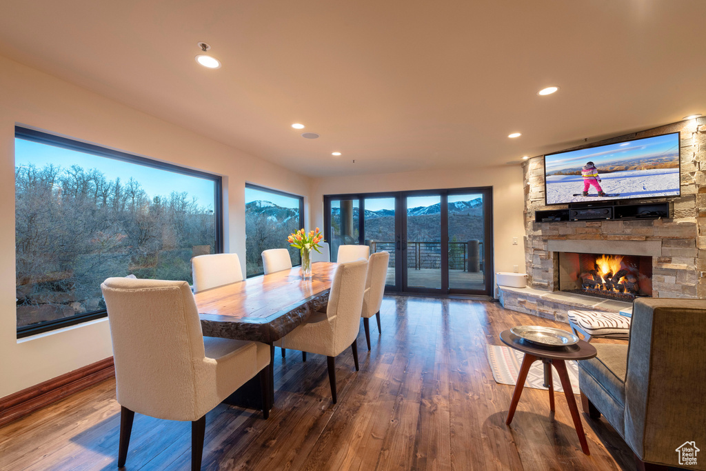 Dining space with wood finished floors, recessed lighting, baseboards, and a fireplace