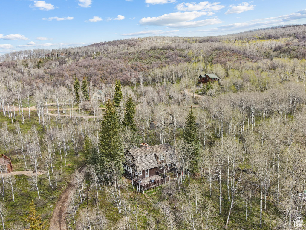 Aerial view of property and surrounding area featuring a forest