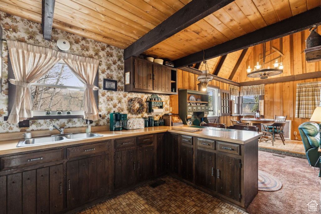Kitchen with a sink, wooden ceiling, light countertops, open shelves, and a peninsula