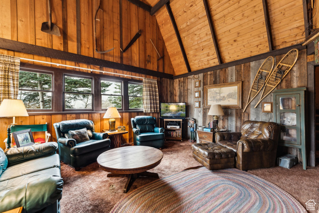 Living room featuring carpet flooring, wooden walls, high vaulted ceiling, wood ceiling, and beam ceiling