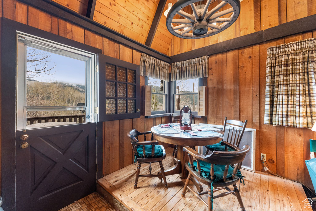 Dining area with wood walls, wooden ceiling, a chandelier, and wood-type flooring