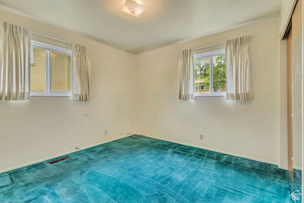 Carpeted empty room featuring baseboards