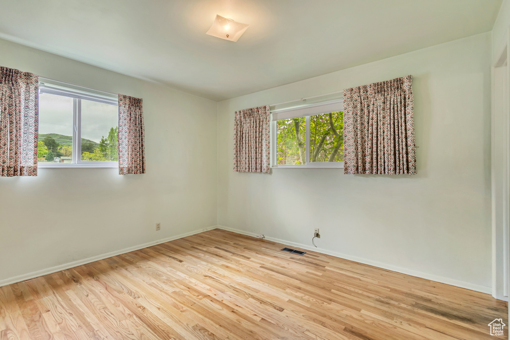 Unfurnished room featuring baseboards and wood finished floors