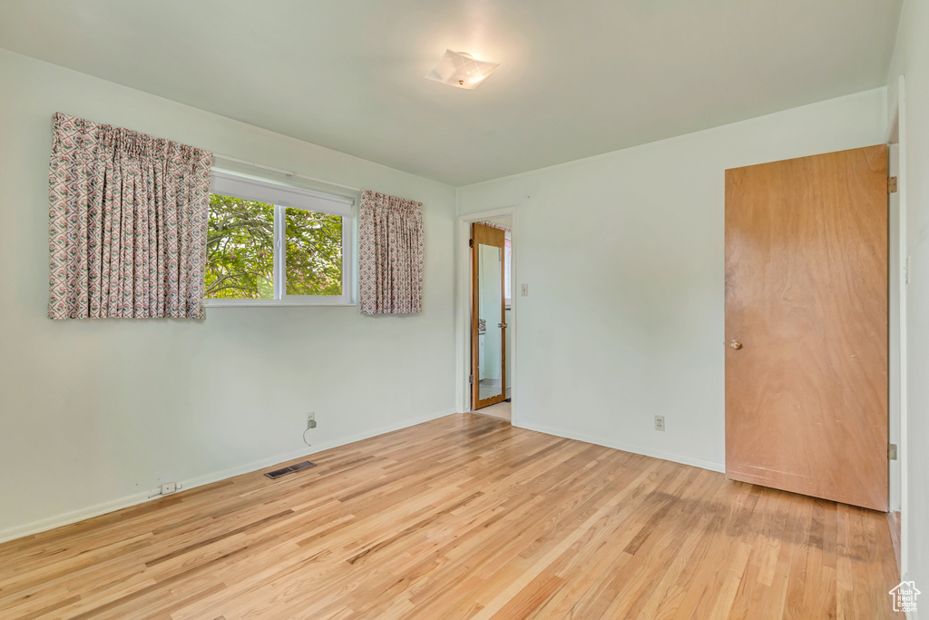 Unfurnished room featuring wood finished floors and baseboards