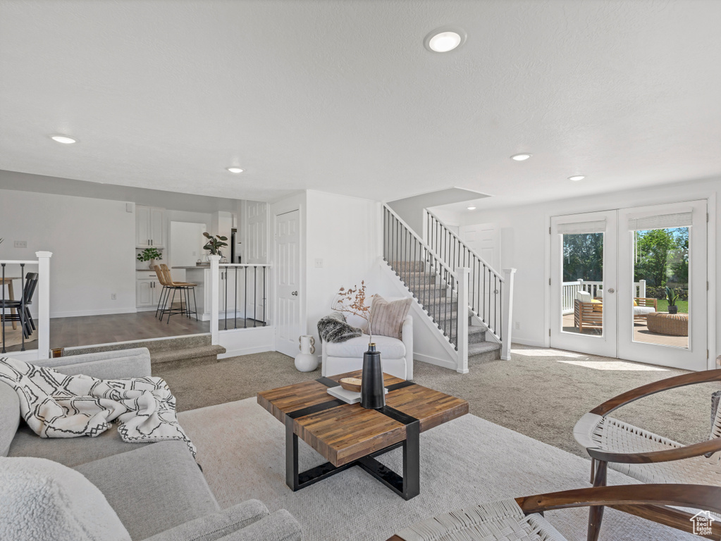 Living area featuring carpet floors, stairway, recessed lighting, french doors, and baseboards