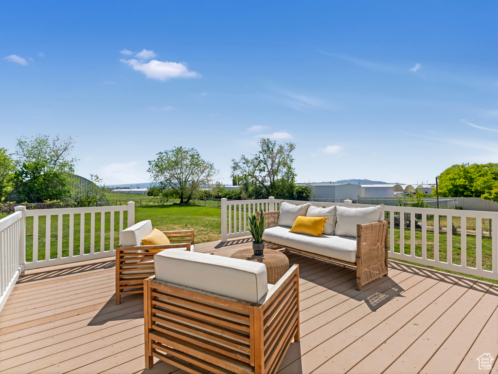 Wooden terrace with an outdoor living space and a yard