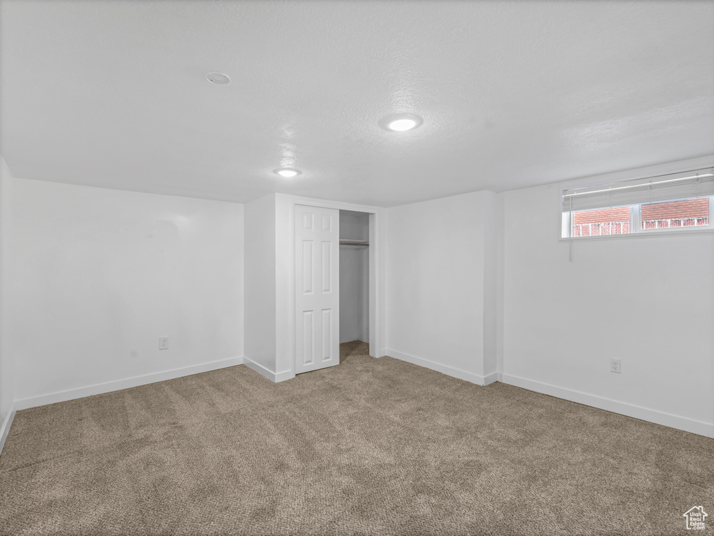Basement featuring carpet flooring and baseboards