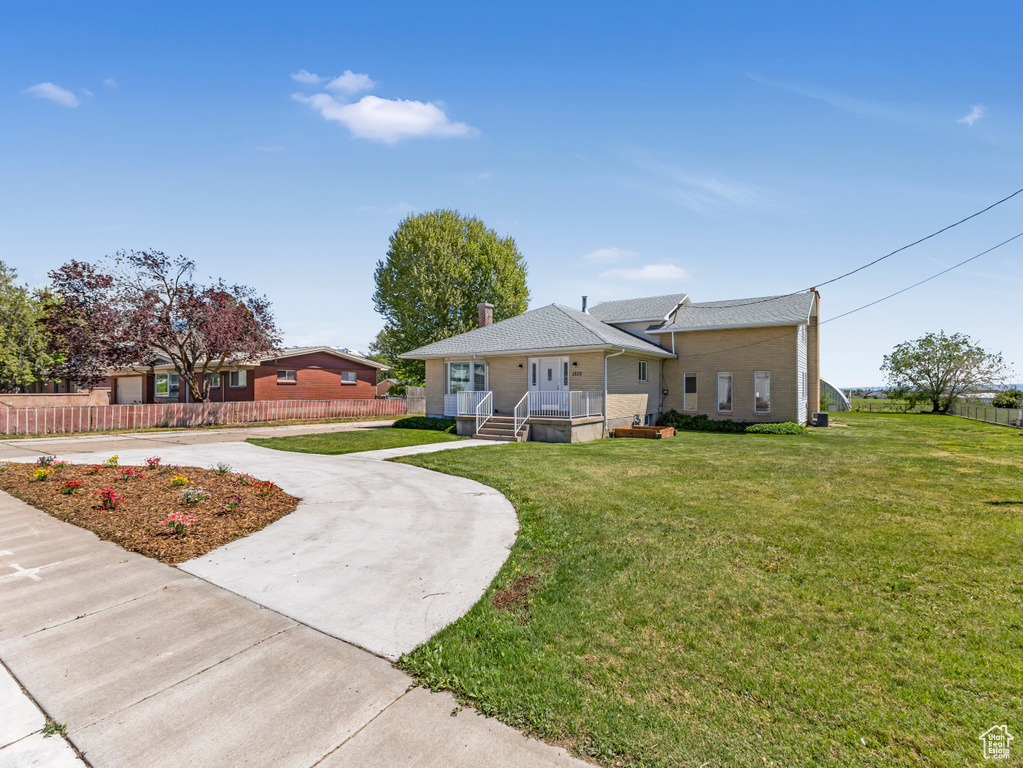 Bungalow with curved driveway, covered porch, a chimney, and a shingled roof