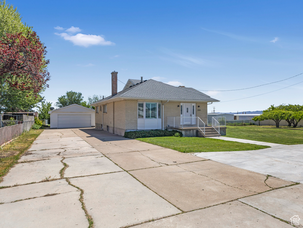 Bungalow-style house with brick siding, a garage, a chimney, an outbuilding, and covered porch