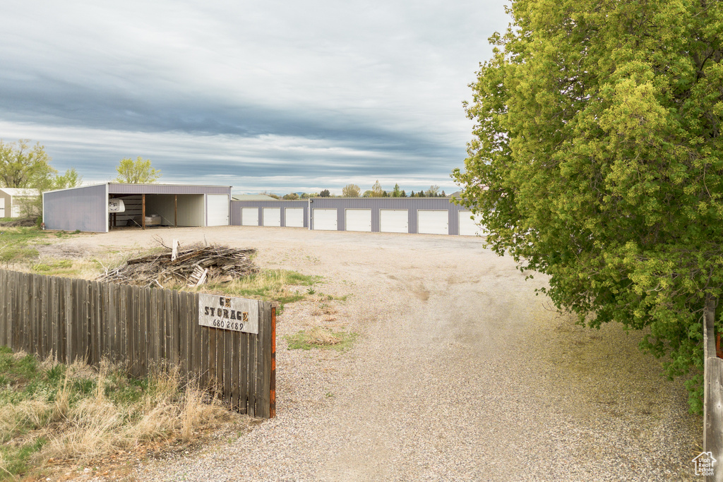 View of yard featuring fence, a pole building, and an outbuilding