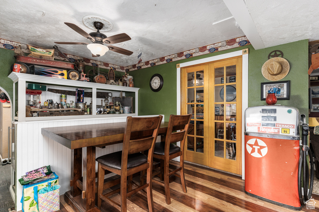 Dining room featuring a bar, ceiling fan, and wood finished floors