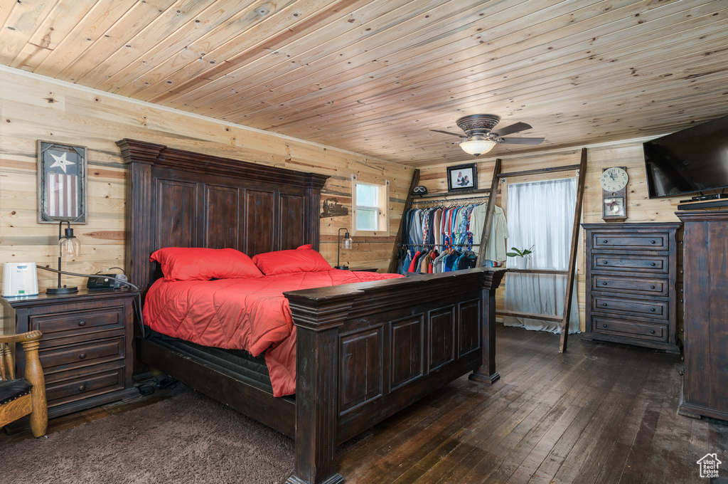 Bedroom with wooden walls, wood ceiling, wood-type flooring, and a ceiling fan