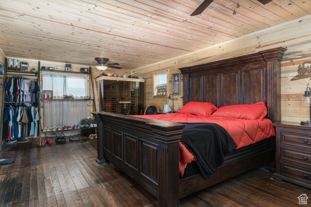 Bedroom featuring dark wood-type flooring, wood ceiling, and wooden walls