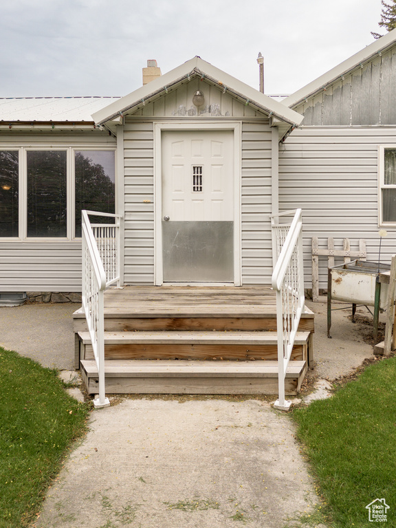 Property entrance with board and batten siding and a chimney